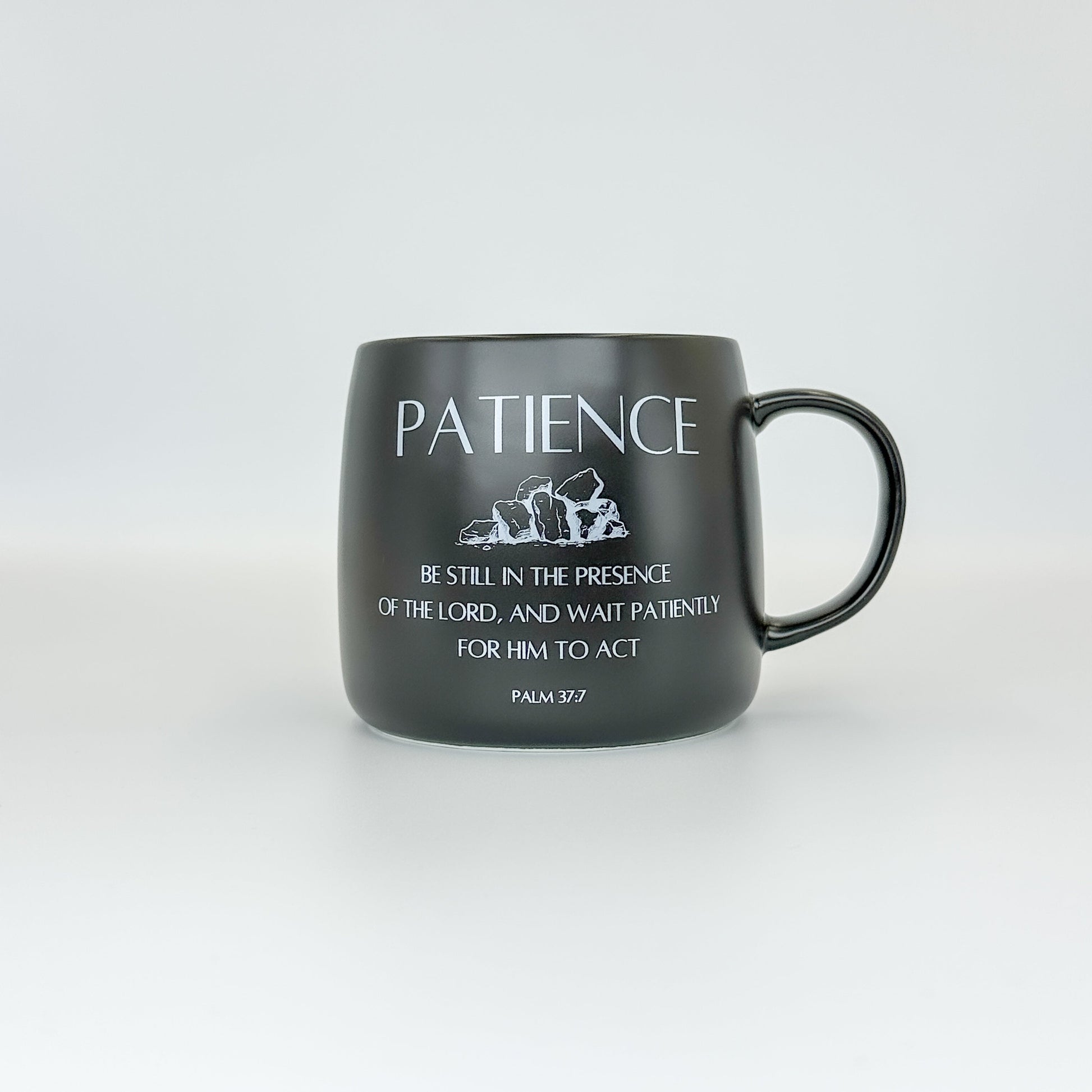 Black mug with white text on a light gray background